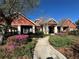 Clubhouse exterior with stone walkway, pretty flowerbeds, mature trees, and classic red brick at 2168 Continental St, St Cloud, FL 34769