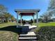 Charming gazebo with stone pillars, a wooden bench, and well-maintained landscaping in a community park at 2168 Continental St, St Cloud, FL 34769