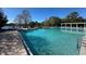 Community pool with sparkling water and sun loungers overlooking a lake at 2168 Continental St, St Cloud, FL 34769