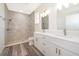 Modern bathroom featuring double vanity, sleek fixtures, and a stylish tiled shower with a glass door at 248 Robin Rd, Altamonte Springs, FL 32701