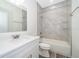 A modern bathroom with shower and tub combination, decorative marble-look tiling, and a white vanity sink at 248 Robin Rd, Altamonte Springs, FL 32701