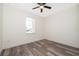 This bedroom features modern wood-look flooring, a ceiling fan, and a window with neighborhood views at 248 Robin Rd, Altamonte Springs, FL 32701