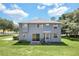 Rear view of two-story house with well-kept lawn, patio, and manicured landscaping at 2581 Ponkan Summit Dr, Apopka, FL 32712