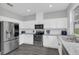 Well-lit kitchen featuring white cabinets, stainless steel appliances, granite countertops, and modern fixtures at 2581 Ponkan Summit Dr, Apopka, FL 32712