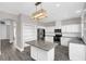 Modern kitchen with white cabinets, granite countertops, stainless steel appliances, and an island, with hardwood floors throughout at 2581 Ponkan Summit Dr, Apopka, FL 32712