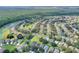 Aerial view of a vibrant community featuring lush green landscaping, mature trees, and a serene lake at 2676 Emerald Island Blvd, Kissimmee, FL 34747