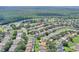 Neighborhood aerial view showcasing well-maintained homes with pools and manicured lawns, backing onto a lush forest at 2676 Emerald Island Blvd, Kissimmee, FL 34747