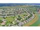 Aerial of suburban homes, many featuring pools, on manicured lawns close to green spaces and lakes at 2676 Emerald Island Blvd, Kissimmee, FL 34747