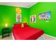 Vibrant bedroom with gaming-themed decor, red bedding, and ample natural light at 2676 Emerald Island Blvd, Kissimmee, FL 34747