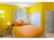 Bright bedroom featuring sunny yellow walls, a large window, and a comfortable queen size bed at 2676 Emerald Island Blvd, Kissimmee, FL 34747