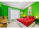 Bright bedroom featuring vibrant green walls, playful Mario decor, and a comfortable red bed at 2676 Emerald Island Blvd, Kissimmee, FL 34747