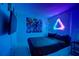 The bedroom has neon lighting, with a graphic poster and a dark comforter at 2676 Emerald Island Blvd, Kissimmee, FL 34747