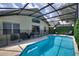 A screened-in pool with a patio area, complete with outdoor furniture for relaxation and enjoyment at 2676 Emerald Island Blvd, Kissimmee, FL 34747