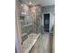 Beautifully tiled walk-in shower with glass enclosure, stone floor, and built-in bench at 272 Cedar Bark Ln, Sanford, FL 32771