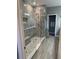 Beautifully tiled walk-in shower with glass enclosure, stone floor, and built-in bench at 272 Cedar Bark Ln, Sanford, FL 32771