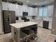 Bright kitchen features an island with seating, white cabinets and stainless appliances at 272 Cedar Bark Ln, Sanford, FL 32771