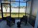 Inviting screened patio furnished with cozy chairs, perfect for relaxation and outdoor enjoyment at 272 Cedar Bark Ln, Sanford, FL 32771