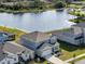 Aerial view of a modern two-story home near a lake with well-maintained landscaping and a driveway at 2729 Timbergrove St, St Cloud, FL 34771