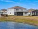 The backyard of a two-story home has a screened patio and overlooks a waterfront view at 2729 Timbergrove St, St Cloud, FL 34771