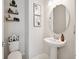 Cozy half-bathroom featuring a round mirror, pedestal sink, and decorative shelves at 2729 Timbergrove St, St Cloud, FL 34771