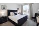 Stylishly decorated bedroom with a plush black bed, accent pillows, and large window at 2729 Timbergrove St, St Cloud, FL 34771