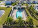 Aerial view of a community pool with lounge chairs, palm trees, and lush landscaping at 2729 Timbergrove St, St Cloud, FL 34771