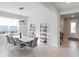 Dining room with white table, stylish chairs, modern lighting and decorative shelving at 2729 Timbergrove St, St Cloud, FL 34771