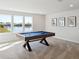 Bright game room with carpet and a pool table overlooking a scenic water view from three large windows at 2729 Timbergrove St, St Cloud, FL 34771