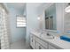 Bright bathroom with white vanity, updated fixtures, and tiled floors near the shower with curtain at 3030 Kingfisher Dr, Orlando, FL 32806