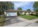 Single-story home showcasing a driveway leading to the garage, surrounded by lush lawn at 3030 Kingfisher Dr, Orlando, FL 32806