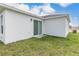 Side exterior view showing a sliding glass door leading to a grassy backyard at 304 Towns Cir, Haines City, FL 33844