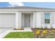 Welcoming home exterior showcasing a well-manicured lawn, a charming front door and an attached garage at 304 Towns Cir, Haines City, FL 33844