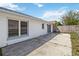 A fenced backyard has a concrete patio off a house with white siding and double windows at 3175 Arrowhead Ln, Kissimmee, FL 34746