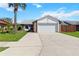 Inviting home with a two-car garage, a well-maintained driveway, and lush green grass at 3175 Arrowhead Ln, Kissimmee, FL 34746