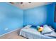 Bedroom with blue walls, a bed with decorative pillows and a louvred closet at 3455 Jujube Dr, Orlando, FL 32810