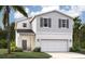 Two-story home boasts a light gray exterior with stone accents and a two-car garage at 3483 Salvia Ct, Tavares, FL 32778