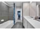 Modern bathroom showcasing gray tiling, vanity with white countertop, and sleek, contemporary fixtures at 3489 Salvia Ct, Tavares, FL 32778