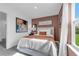 Bright bedroom featuring neutral walls, cozy decor, and a picturesque view of the outdoor greenery at 3489 Salvia Ct, Tavares, FL 32778