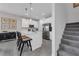 Well-lit kitchen featuring an island with barstool seating, stainless appliances, and carpeted staircase at 3489 Salvia Ct, Tavares, FL 32778