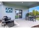 Relaxing covered patio featuring comfortable outdoor seating and a dining table with a view of the landscaped backyard at 3489 Salvia Ct, Tavares, FL 32778