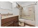 Bathroom featuring granite countertop, wood cabinet, shower and tub with glass doors, and wood look flooring at 35 Misners Trl, Ormond Beach, FL 32174