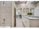 Bright bathroom featuring a dual sink vanity with granite counters, and a tile shower at 3590 Dahlia Dr, Haines City, FL 33844