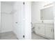 Bright bathroom with white vanity, tile floors, and an open doorway to a walk-in closet at 3892 Sw 130Th Loop, Ocala, FL 34473