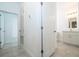 Bright hallway leading to a renovated bathroom with a modern vanity and a tiled floor at 3892 Sw 130Th Loop, Ocala, FL 34473