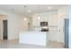 Bright, white kitchen featuring a central island with pendant lighting and stainless steel appliances at 3892 Sw 130Th Loop, Ocala, FL 34473