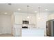 Bright kitchen featuring white cabinets, stainless steel appliances, and modern pendant lighting at 3892 Sw 130Th Loop, Ocala, FL 34473