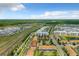 Overhead view showcases residential buildings next to a scenic lake and roads, set against a clear blue sky at 4865 Clock Tower Dr, Kissimmee, FL 34746