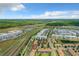 Expansive aerial shot of residential buildings, a central lake, and winding roads on a sunny day at 4865 Clock Tower Dr, Kissimmee, FL 34746