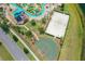 Aerial view of a community pool, beach volleyball court, and basketball court with beautiful surroundings at 4865 Clock Tower Dr, Kissimmee, FL 34746