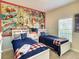 Fun bedroom featuring comic-themed wall art, two twin beds with cozy bedding, and a bright window at 4865 Clock Tower Dr, Kissimmee, FL 34746